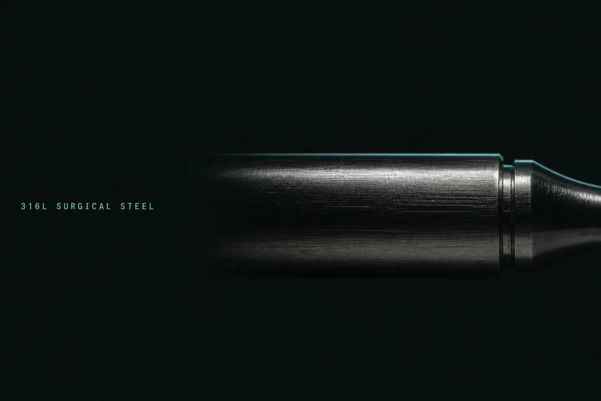 Extreme macro of the Habit Anchor in brushed 316L surgical steel, edge-lit in mint on a near-black field