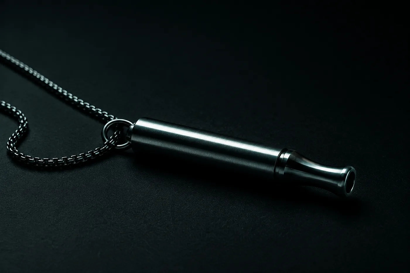 The Habit Anchor and its chain up close - brushed 316L steel body and mouthpiece on a dark surface