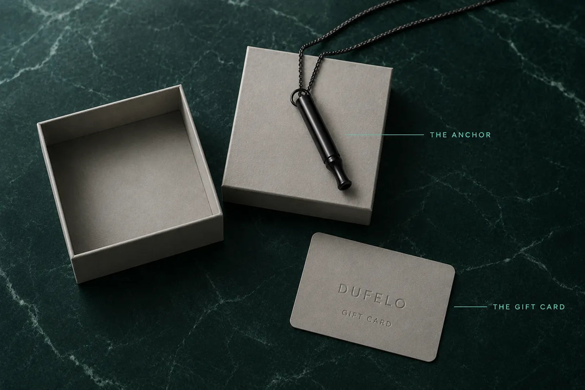 Everything in the Kit - the black Habit Anchor on its chain, the gift box and the Dufelo gift card on deep green marble
